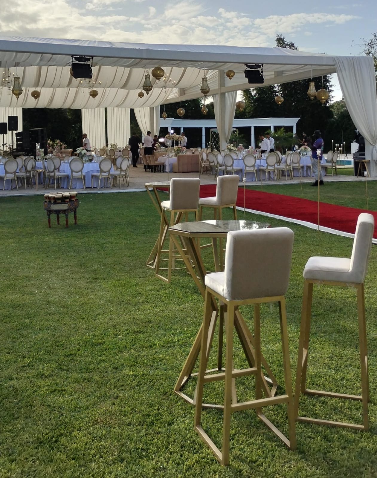 Réception de soirée en extérieur, mange-debout dorés et tapis rouge