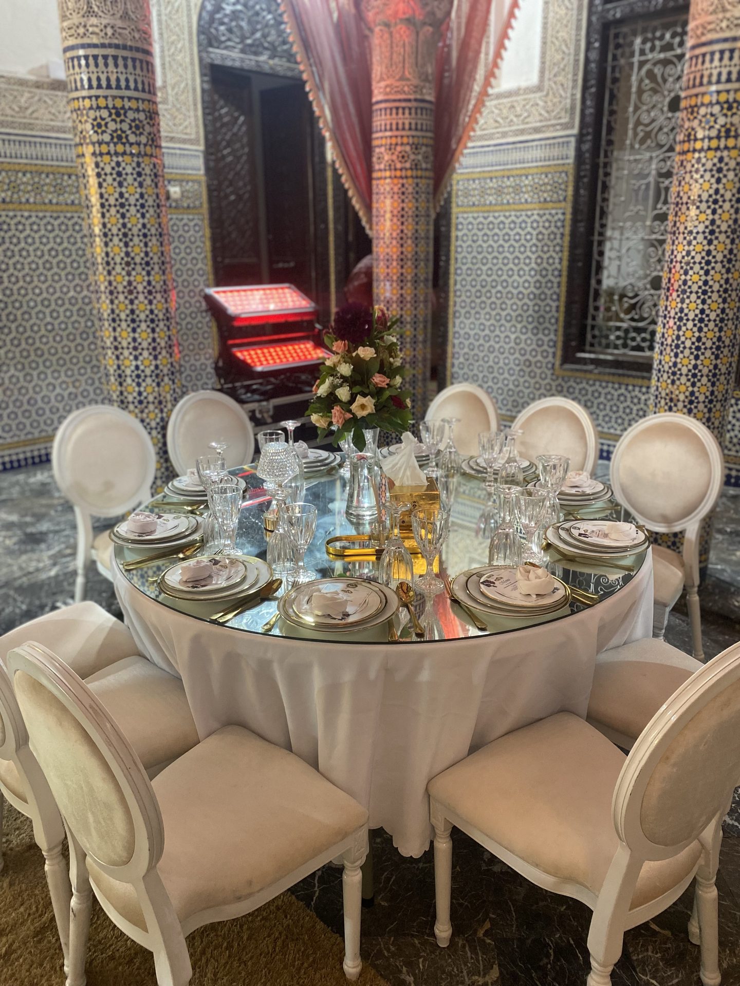 Table ronde à plateau miroir dans un riad aux colonnes de zellige